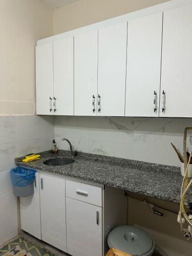 a white kitchen with a sink and white cabinets at Hostel Nelly in Istanbul