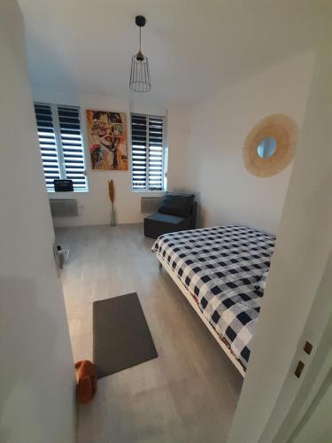 une chambre avec un lit et une chaise dedans dans l'établissement Apaartement près du Stade du Hainaut, à Marly