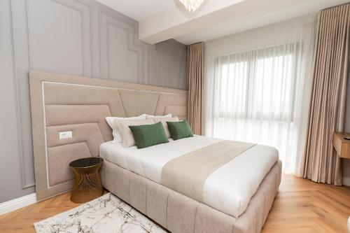 a bedroom with a large bed with green pillows at Luxe Apartment - NEO TOWER in Suceava