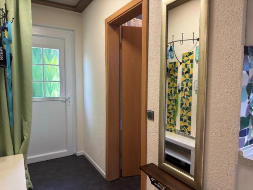 einen Flur mit Tür und Spiegel in einem Zimmer in der Unterkunft Apartment in Kellerwald near Edersee Lake in Frankenau