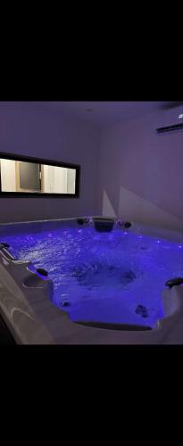 La salle de bains est pourvue d'une baignoire bleue. dans l'établissement Spa&love, à Istres