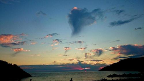 a cloudy sky over the ocean at sunset at Ana & Angelo House Vuno Himare in Vuno