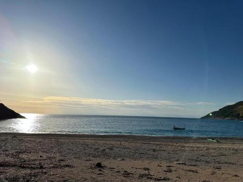 a beach with a boat in the water at Ana & Angelo House Vuno Himare in Vuno