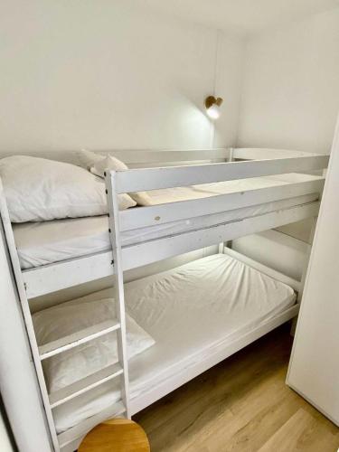 - un lit superposé blanc dans une petite chambre dans l'établissement Résidence Joigny - Studio cabine rénové avec vue sur le bassin – Quartier Notre-Dame, Joigny MAE-8924, à Arcachon