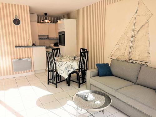 - un salon avec une table et un bateau sur le mur dans l'établissement Résidence Anthinea - Arcachon - T2 vue sur mer au calme MAE-9544, à Arcachon