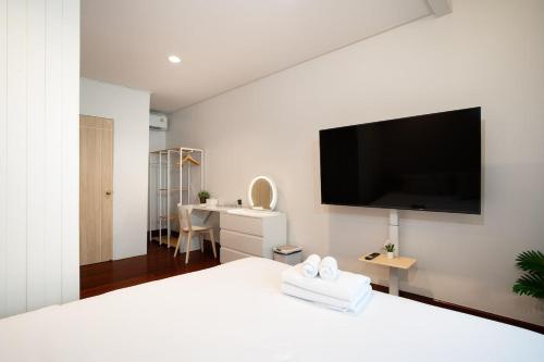 a bedroom with a bed with a flat screen tv on the wall at 2BR 1BA Home In Yaowarat 5 Min MRT Nivas Wanit ECO in Bangkok