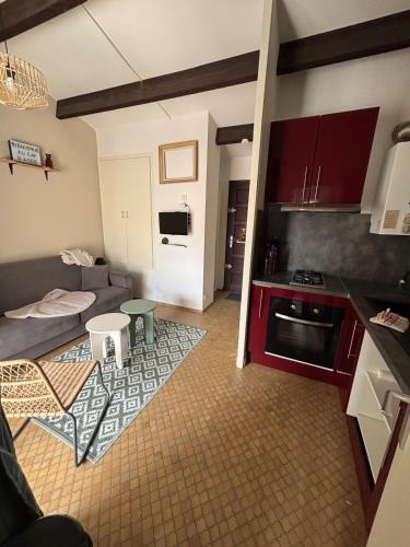 une cuisine et un salon avec un canapé et une table dans l'établissement 150m plage de la conque et commerces appartement 4p, au Cap d'Agde