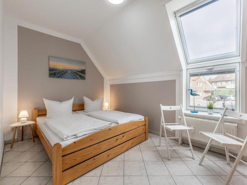 a bedroom with a wooden bed and a window at Charmante Ferienwohnung in Kirchdorf Insel Poel in Oertzenhof