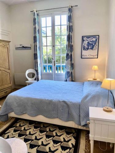 une chambre avec un lit bleu et une fenêtre dans l'établissement Résidence 385-arcachon - Appartement cosy pour famille, avec parking et balcons privés MAE-8884, à Arcachon