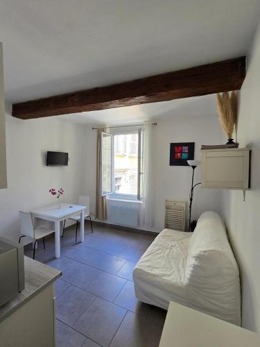 une chambre avec un lit et une table dedans dans l'établissement Les CARMES 1 G pour 2 pers - joli meublé et Wi-Fi, à Avignon