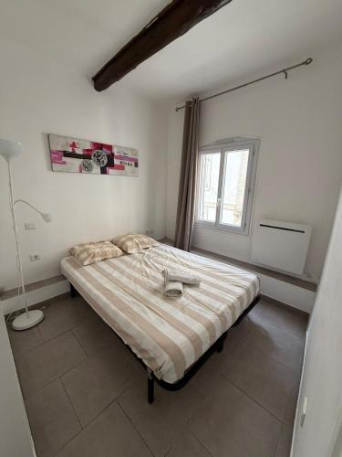 une chambre avec un lit dans une pièce avec une fenêtre dans l'établissement Les CARMES 1 G pour 2 pers - joli meublé et Wi-Fi, à Avignon