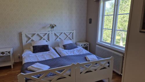 a bedroom with two beds and a window at Pensionat Klåvasten in Skövde