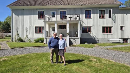 a man and woman standing in front of a house at Pensionat Klåvasten in Skövde