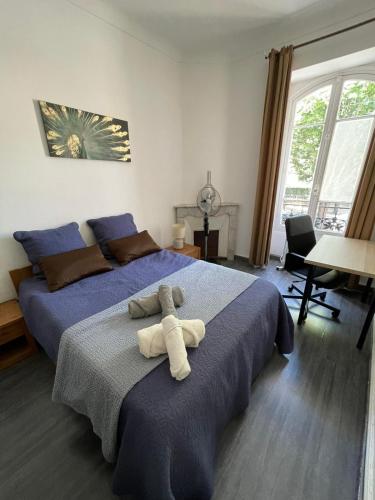 une chambre avec un lit avec un animal en peluche dessus dans l'établissement 2 spacious bedrooms near Riquier station!, à Nice