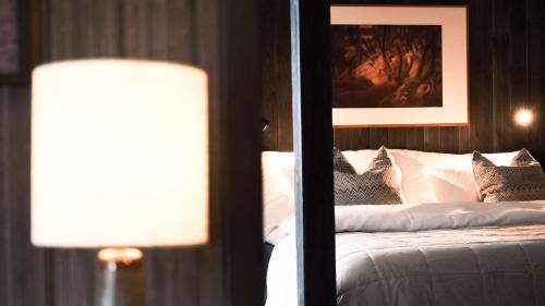 a bedroom with a bed with a picture on the wall at Sov Lodge in Vågåmo