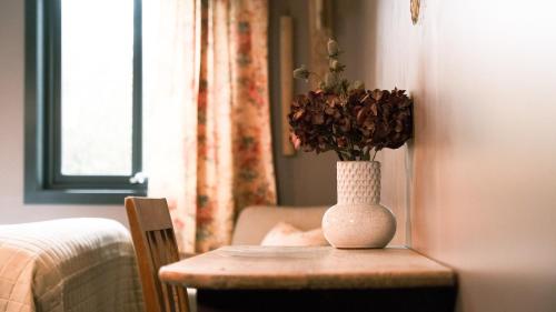 a vase with flowers on a table in a room at Sov Lodge in Vågåmo