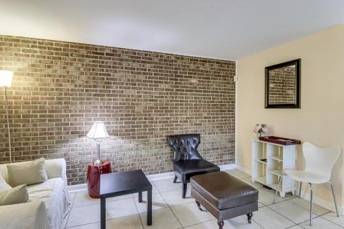a living room with a brick wall at 1 Mi to UMD Convenient and Cozy Condo with Patio! in Berwyn Heights