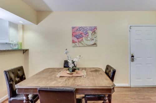 a dining room with a wooden table and chairs at 1 Mi to UMD Convenient and Cozy Condo with Patio! in Berwyn Heights