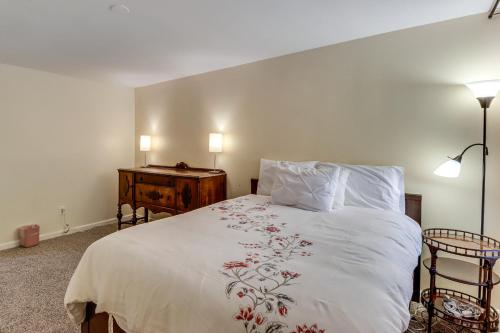 a bedroom with a large white bed and a table at 1 Mi to UMD Convenient and Cozy Condo with Patio! in Berwyn Heights