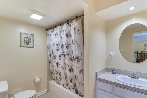 a bathroom with a sink and a shower curtain at 1 Mi to UMD Convenient and Cozy Condo with Patio! in Berwyn Heights