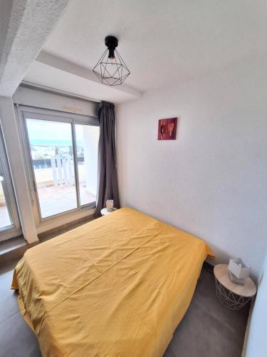 une chambre avec un lit jaune et une fenêtre dans l'établissement Résidence Port Nature Colline 5 - Studio 2 pers - Port Nature Colline 5 MAE-2844, au Cap d'Agde