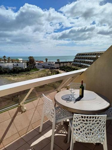 une table et des chaises sur un balcon avec vue sur l'océan dans l'établissement Résidence Héliopolis Bâtiment E - studio 2 Pers. Héliopolis Bât. E MAE-4474, au Cap d'Agde