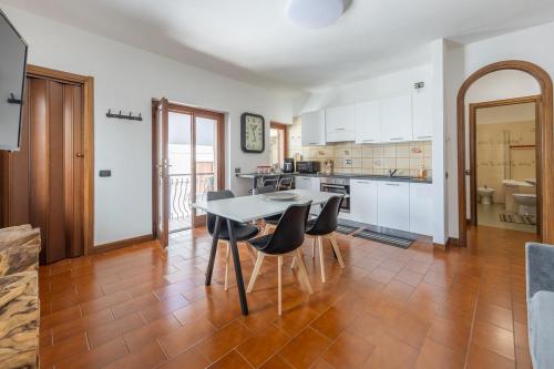 a kitchen with a table and chairs in a room at Appartamento nel Cuore dI Barzio in Barzio