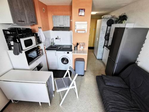 une petite cuisine avec un réfrigérateur et un micro-ondes dans l'établissement Résidence Belle Plage - 2 Pièces 4 couchages PORT LEUCATE. Réf: 3BP_36D MAE-8313, à Leucate