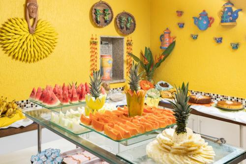 a buffet of fruits and vegetables on a glass table at Kaliman Pousada in Ubatuba