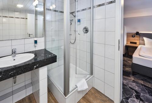 a bathroom with a shower and a sink at Das Landhotel am Trätzhof Fulda in Fulda