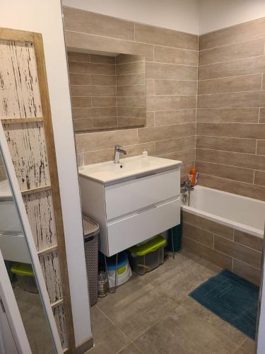 une salle de bain avec un lavabo et une baignoire dans l'établissement Maison standing avec piscine 3 chambres, à Lattes