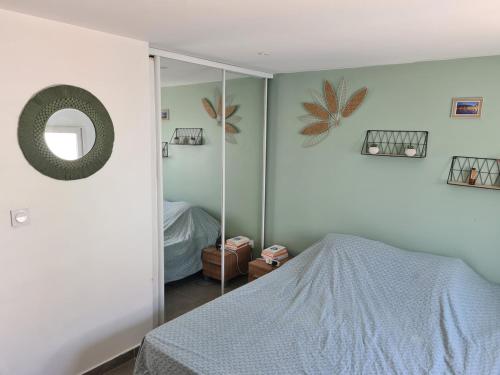 une chambre avec un lit et un miroir dans l'établissement Maison standing avec piscine 3 chambres, à Lattes