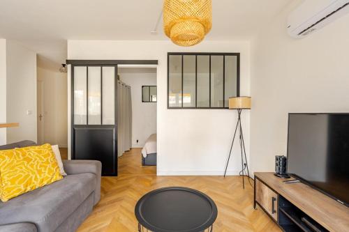 un salon avec un canapé et une télévision dans l'établissement L'Alexandre - Terrace - AC - Cosy - City centre - WIFI, au Cannet