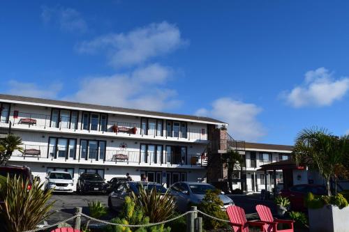 a white building with cars parked in a parking lot at The Landing at Morro Bay in Morro Bay