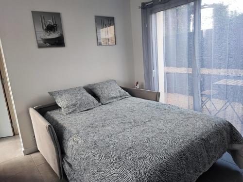 une chambre avec un lit et une grande fenêtre dans l'établissement Le cocon, à Bréal-sous-Montfort