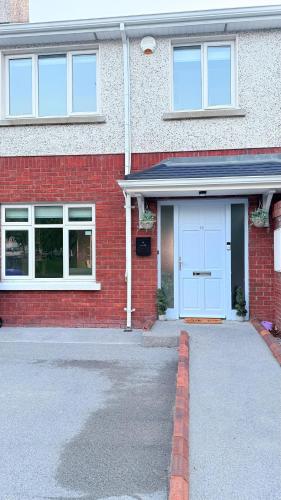 a red brick house with a white garage at Gurteen Village Getaway in Cloonlaheen