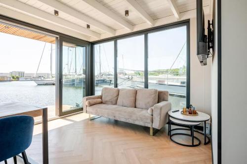 a living room with a couch and a table at Moderne houseboat op het water! in Assendelft
