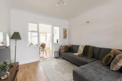 a living room with a couch and a table at Spacious London Oasis in Welling
