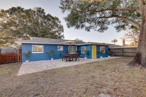 a blue house with a table and chairs in a yard at Calming Getaway 9 Mi to Clearwater Beach! in Clearwater
