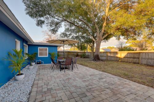 a patio with a table and chairs and an umbrella at Calming Getaway 9 Mi to Clearwater Beach! in Clearwater
