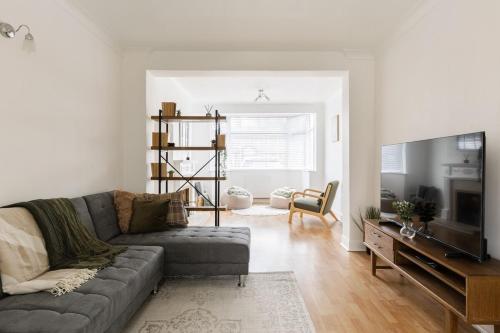 a living room with a couch and a television at Spacious London Oasis in Welling