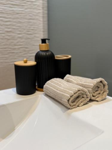 une salle de bain avec deux serviettes et une bouteille sur un lavabo dans l'établissement T1 luxe Hyper centre 100 m du port Clim wifi fibre, à Toulon