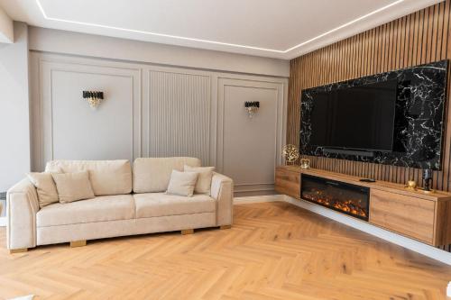 a living room with a couch and a flat screen tv at Maison Apartment - NEO TOWER in Suceava