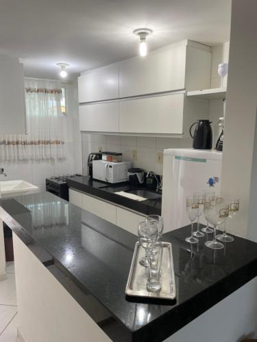 a kitchen with wine glasses on a counter at Mar e sol residencial 2 quartos com ar condicionado,500 metros da praia de Jacumã in Conde