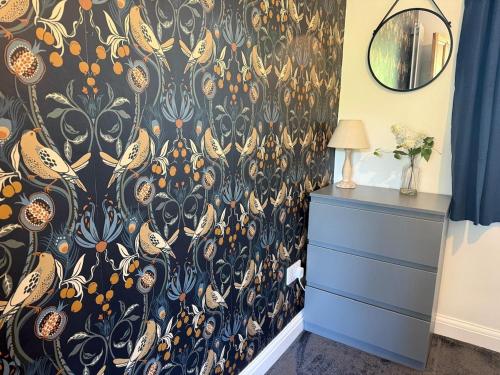 a bedroom with a black and orange wallpaper at Stanton Lodge Cottage - 2 bedrooms - sleeps 5 in Curbar