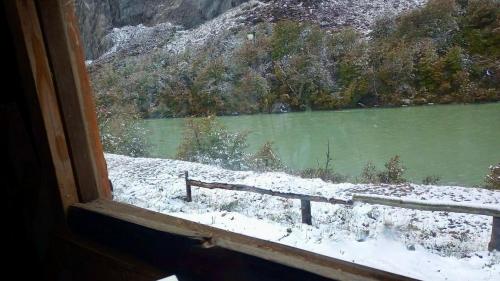 a window with a view of a snow covered lake at Cabaña el ojo de Horus el chalten santa cruz in El Chalten
