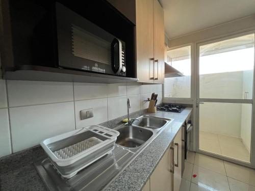 eine Küche mit Spüle und Arbeitsplatte in der Unterkunft Depto familiar en Barrio Italia - 1100 LB in Santiago