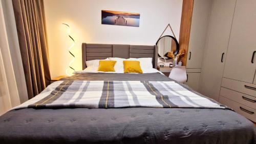 Un dormitorio con una cama grande con almohadas amarillas. en Chic, Sunny and Cozy One Bedroom Bliss, en Varna