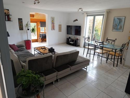 un salon avec un canapé et une table dans l'établissement Villa avec grande piscine, à Nissan-lez-Enserune