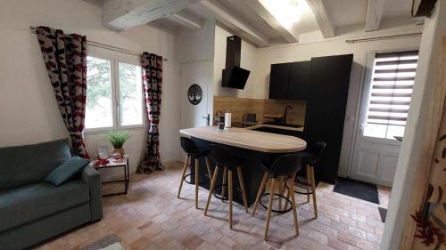 une cuisine avec une table et des chaises dans une pièce dans l'établissement Gîte Elendil - Esprit Champêtre, à Chambon